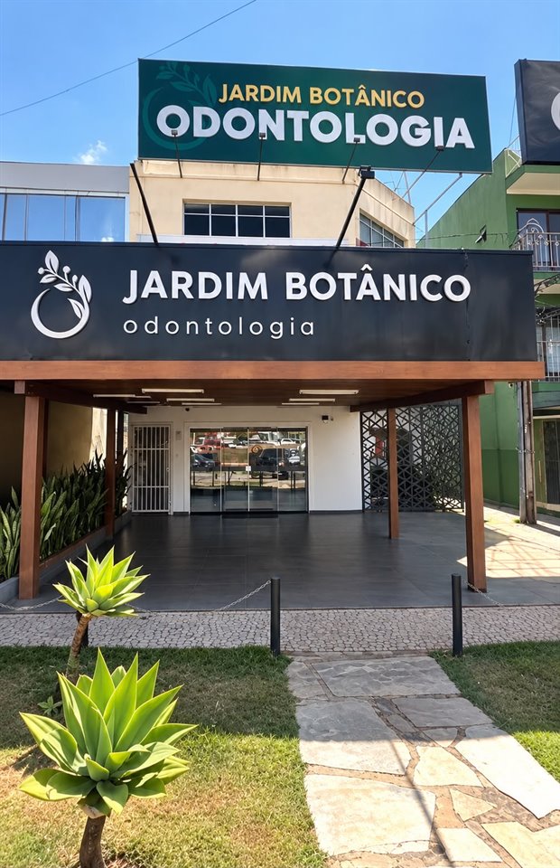 Fachada da Jardim Botânico Odontologia, com letreiro na entrada e jardim na frente